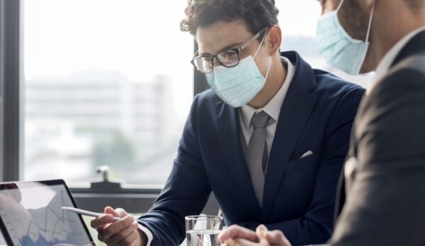 Corporate business men in face mask working in an office new normal