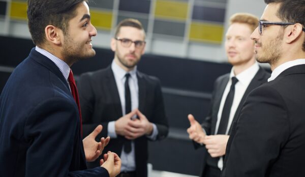 Young businessman voicing his opinion to group of colleagues